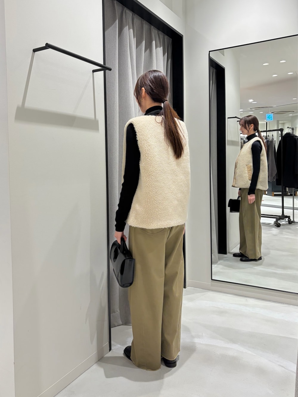 ベージュ系のその他パンツ、ベージュ系のベスト、ブラック系のニット/セーターを着用したレディースの秋コーディネートの3枚目の写真