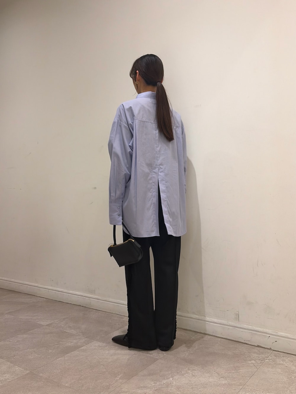 ブラック系のその他シューズ、ブラック系のその他パンツ、ブラック系のハンドバッグを着用したレディースの冬コーディネートの5枚目の写真