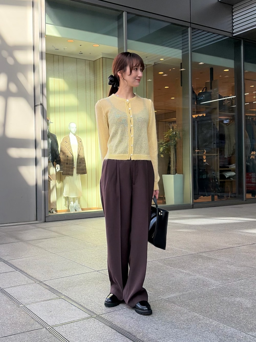 ホワイト系のその他アウター、イエロー系のカーディガン/ボレロ、ブラウン系のその他パンツを着用したレディースの冬コーディネートの5枚目の写真