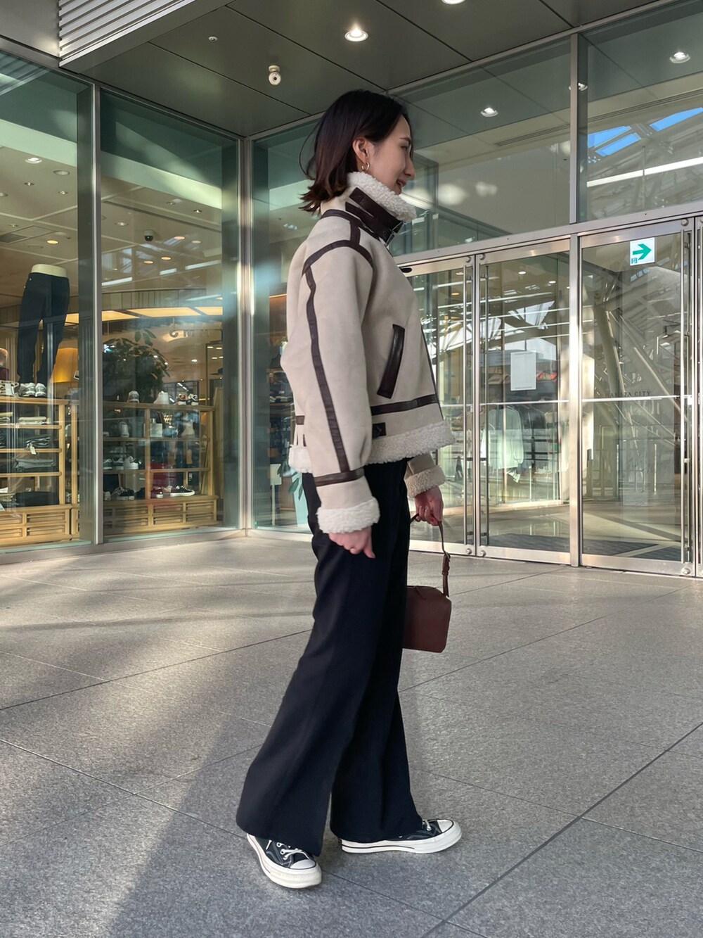 ベージュ系のブルゾン、ブラック系のその他パンツ、ブラウン系のボストンバッグを着用したレディースの冬コーディネートの4枚目の写真