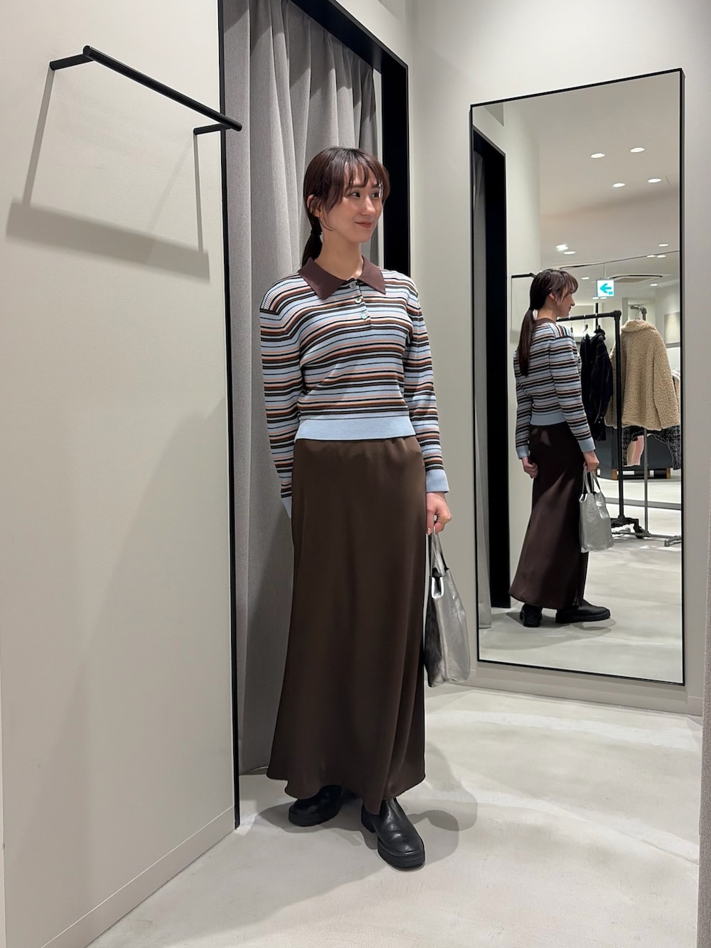 その他のニット/セーター、ホワイト系のピーコート、ブラウン系のスカートを着用したレディースの冬コーディネートの3枚目の写真