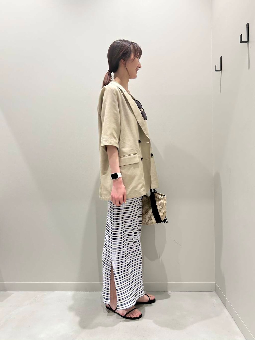 ベージュ系のかごバッグ、ベージュ系のその他アウター、ブラック系のサンダルを着用したレディースの春コーディネートの2枚目の写真