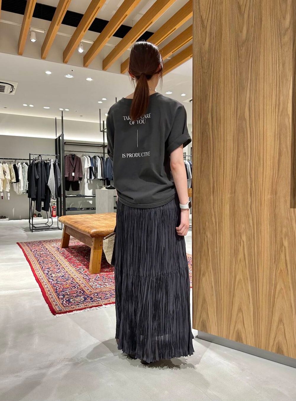 ベージュ系のかごバッグ、グレー系のTシャツ/カットソー、グレー系のスカートを着用したレディースの春コーディネートの4枚目の写真