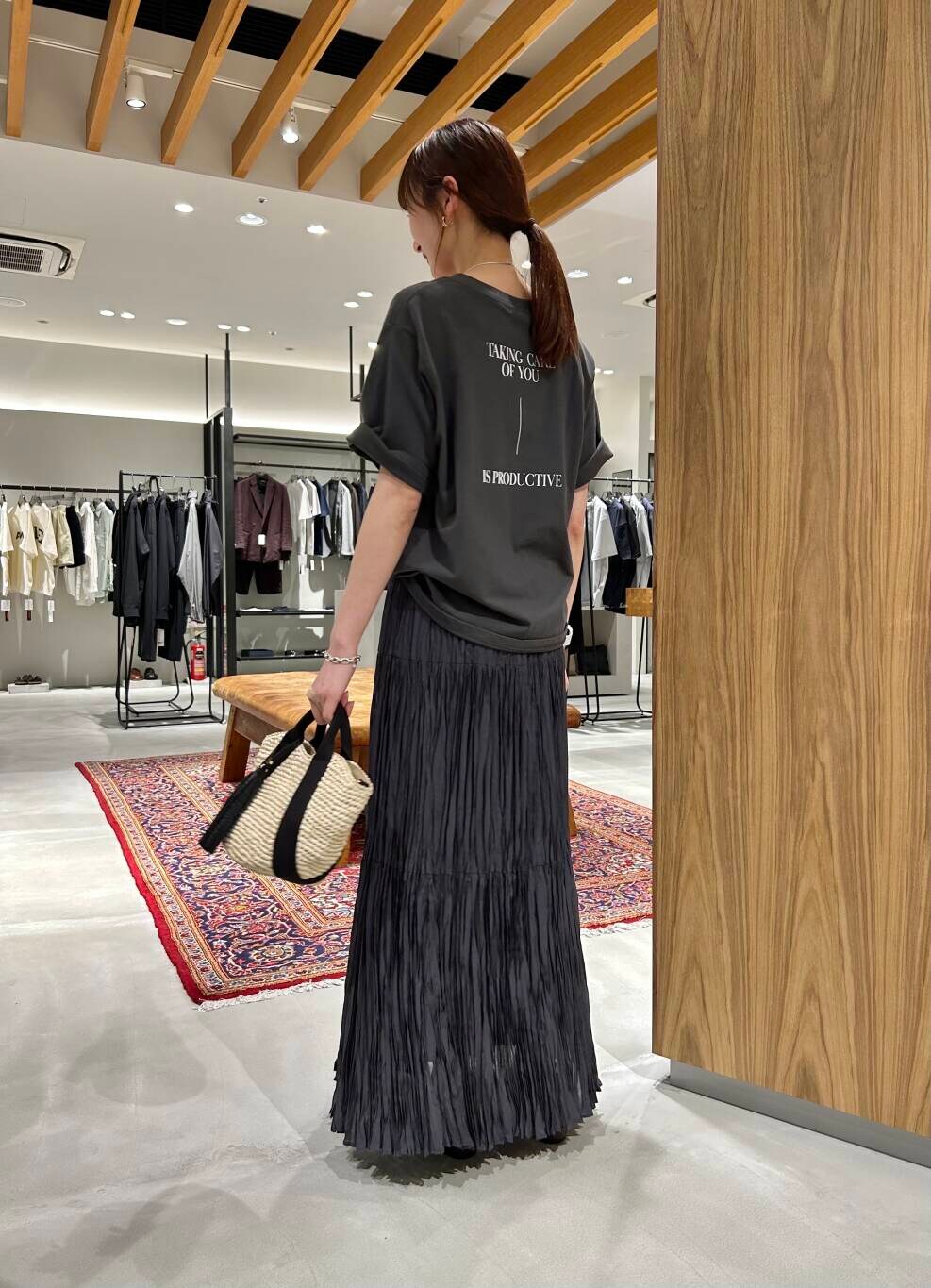 ベージュ系のかごバッグ、グレー系のTシャツ/カットソー、グレー系のスカートを着用したレディースの春コーディネートの3枚目の写真