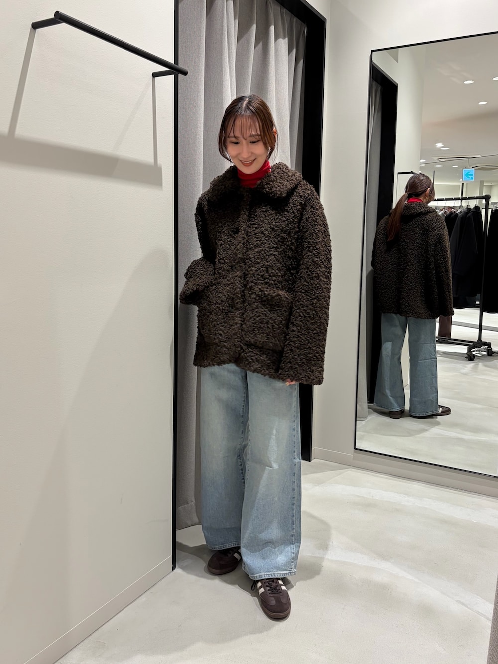 ブラウン系のその他アウター、ブルー系のデニムパンツ、ブラウン系のスニーカーを着用したレディースの秋コーディネートの3枚目の写真