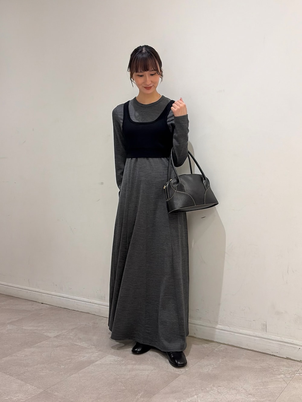 ブラウン系のダウンジャケット/コート、ブラック系のニット/セーター、グレー系のワンピースを着用したレディースの秋コーディネートの4枚目の写真