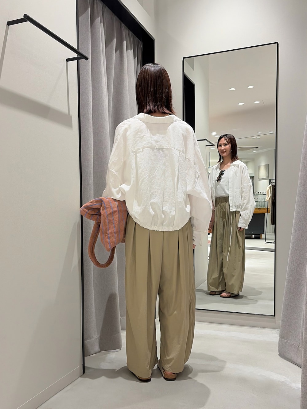 ベージュ系のその他パンツ、ベージュ系のサンダル、イエロー系のトートバッグを着用したレディースの春コーディネートの4枚目の写真