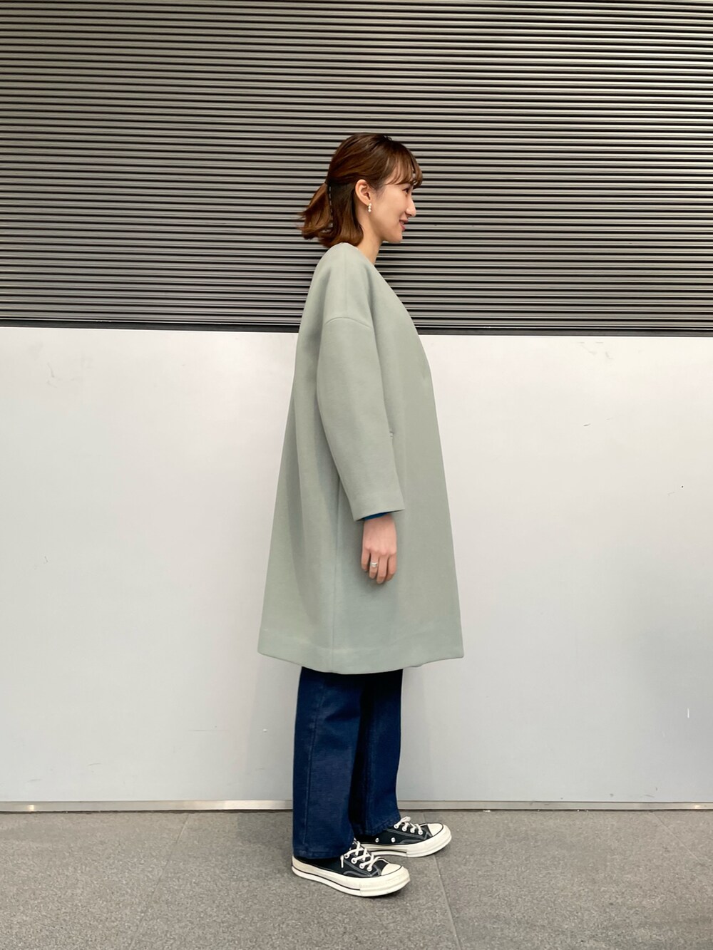 グリーン系のその他アウター、ホワイト系のニット/セーター、ブルー系のデニムパンツを着用したレディースの冬コーディネートの2枚目の写真