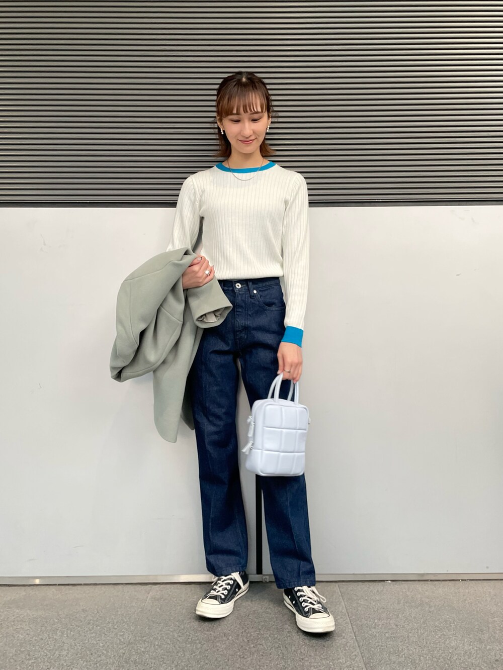 グリーン系のその他アウター、ホワイト系のニット/セーター、ブルー系のデニムパンツを着用したレディースの冬コーディネートの4枚目の写真