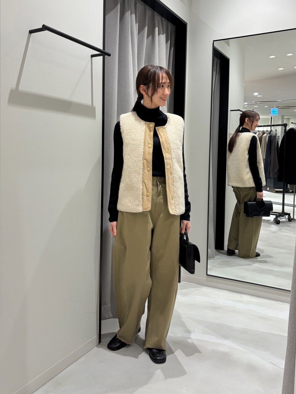 ベージュ系のその他パンツ、ベージュ系のベスト、ブラック系のニット/セーターを着用したレディースの秋コーディネートの2枚目の写真