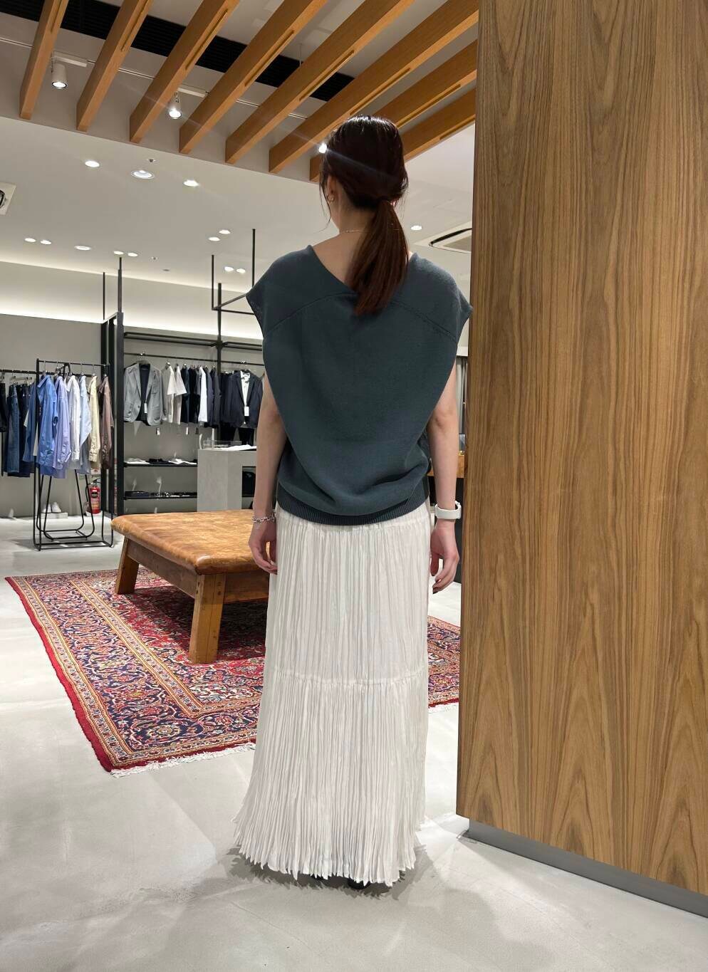 ホワイト系のスカート、ブラウン系のサンダル、ブルー系のベストを着用したレディースの春コーディネートの4枚目の写真