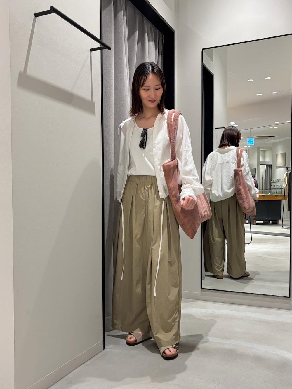 ベージュ系のその他パンツ、ベージュ系のサンダル、イエロー系のトートバッグを着用したレディースの春コーディネートの2枚目の写真