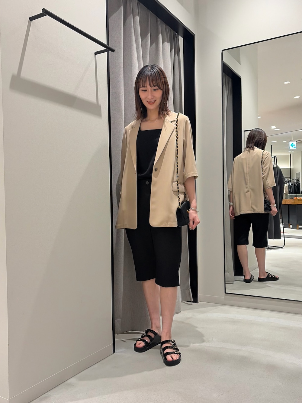 ベージュ系のその他アウター、ブラック系のタンクトップ、ブラック系のその他パンツを着用したレディースの春コーディネートの2枚目の写真
