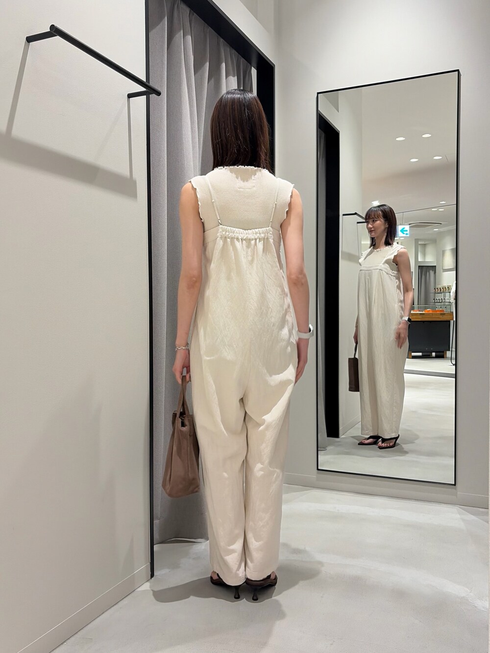 ホワイト系のその他パンツ、ベージュ系のタンクトップ、ブラウン系のサンダルを着用したレディースの春コーディネートの3枚目の写真