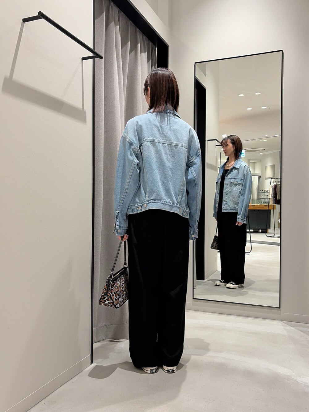 ブラック系のその他パンツ、その他のトートバッグ、ブルー系のデニムジャケットを着用したレディースの春コーディネートの4枚目の写真