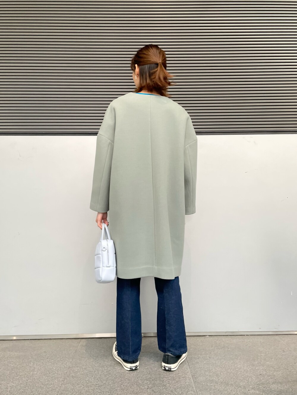 グリーン系のその他アウター、ホワイト系のニット/セーター、ブルー系のデニムパンツを着用したレディースの冬コーディネートの3枚目の写真