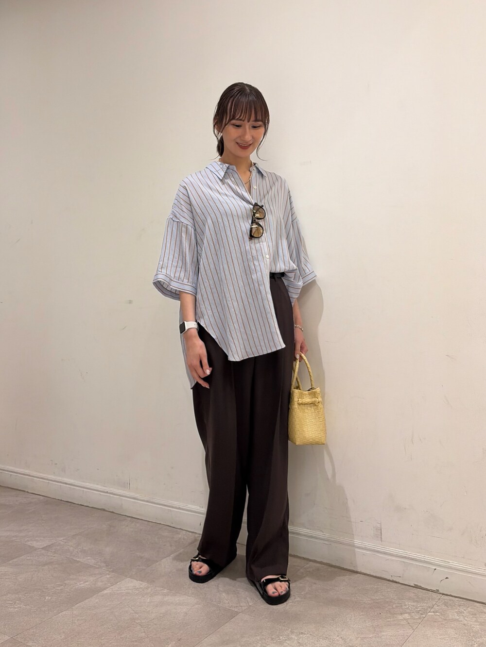 ブラウン系のその他パンツ、ベージュ系のトートバッグ、ブラウン系のシャツ/ブラウスを着用したレディースの夏コーディネートの3枚目の写真