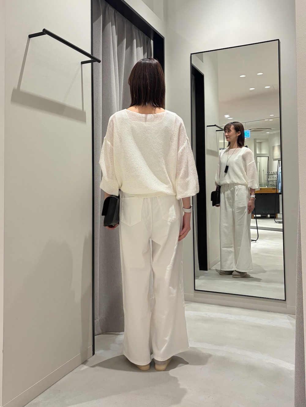 ホワイト系のデニムパンツ、ブラック系のハンドバッグ、グレー系のその他シューズを着用したレディースの春コーディネートの3枚目の写真