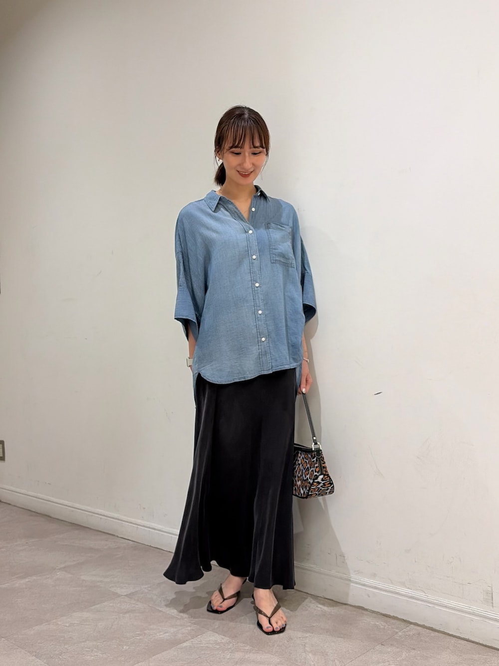 ブルー系のシャツ/ブラウス、ブラック系のサンダル、グレー系のスカートを着用したレディースの夏コーディネートの2枚目の写真