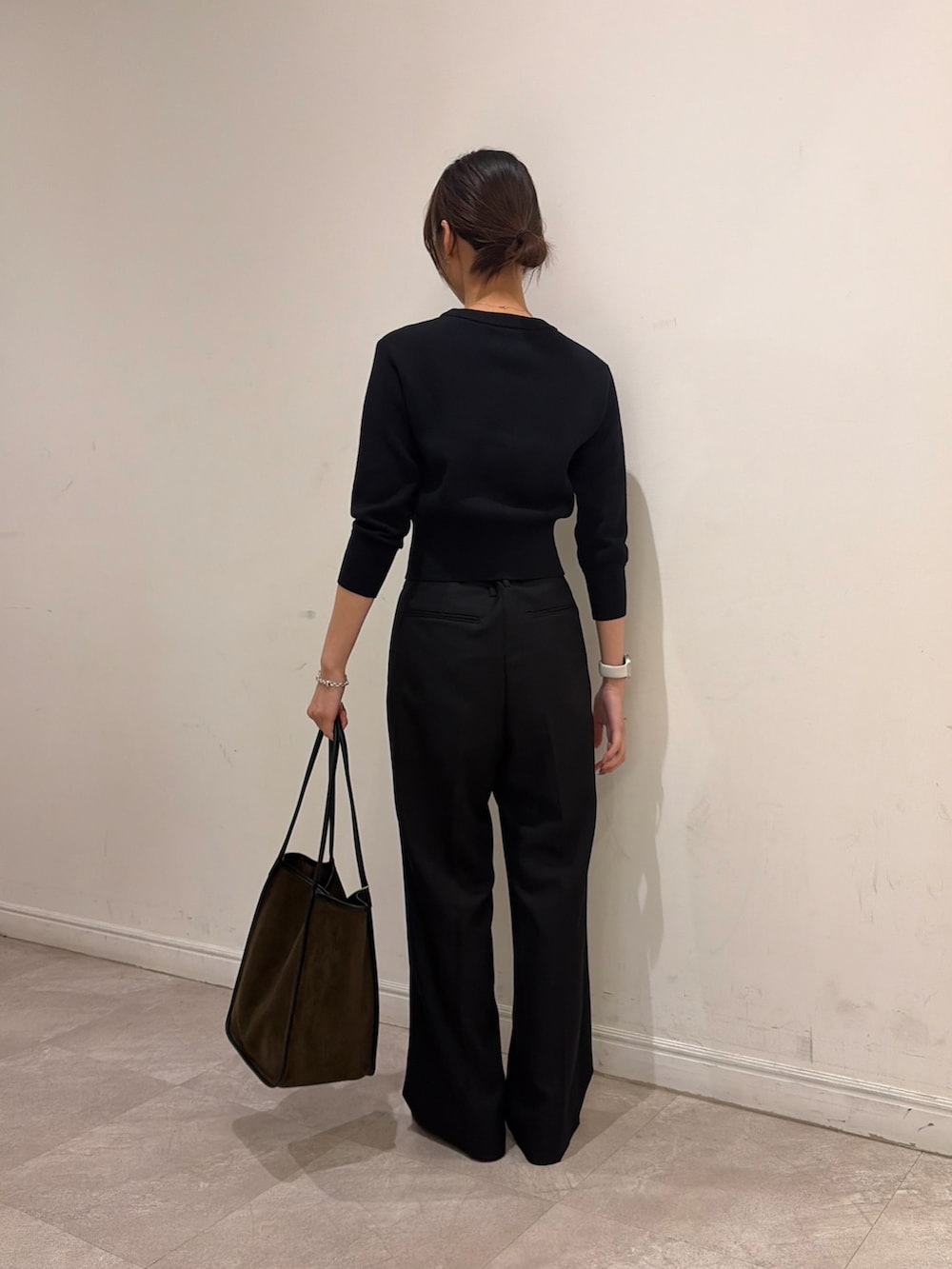 ブラック系のニット/セーター、ブラック系のその他パンツ、グリーン系のトートバッグを着用したレディースの秋コーディネートの4枚目の写真