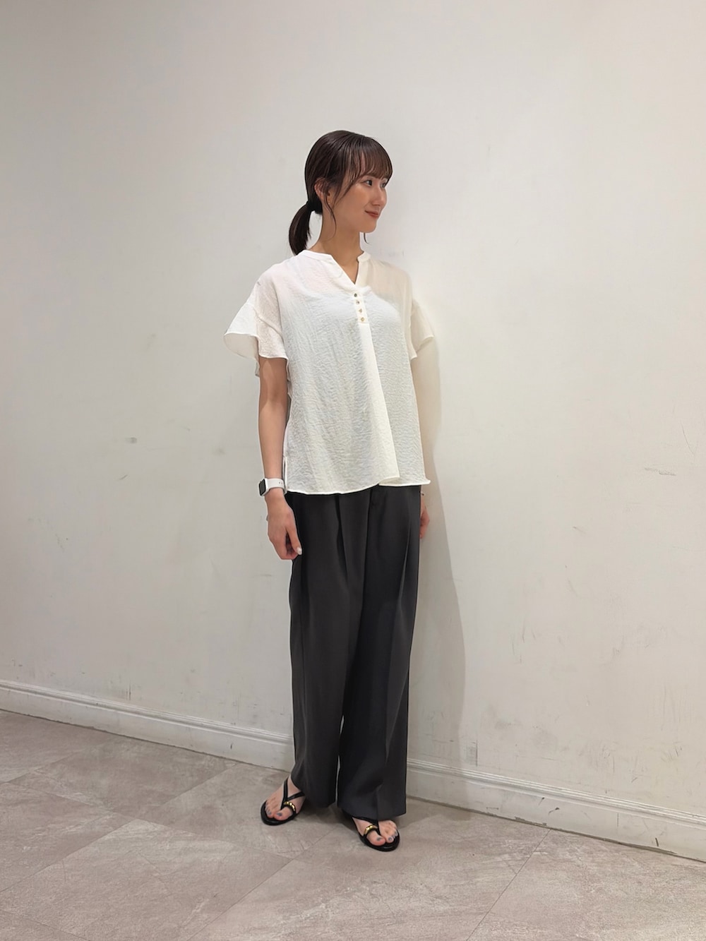 ホワイト系のシャツ/ブラウス、グレー系のその他パンツ、ブラック系のサンダルを着用したレディースの夏コーディネートの2枚目の写真
