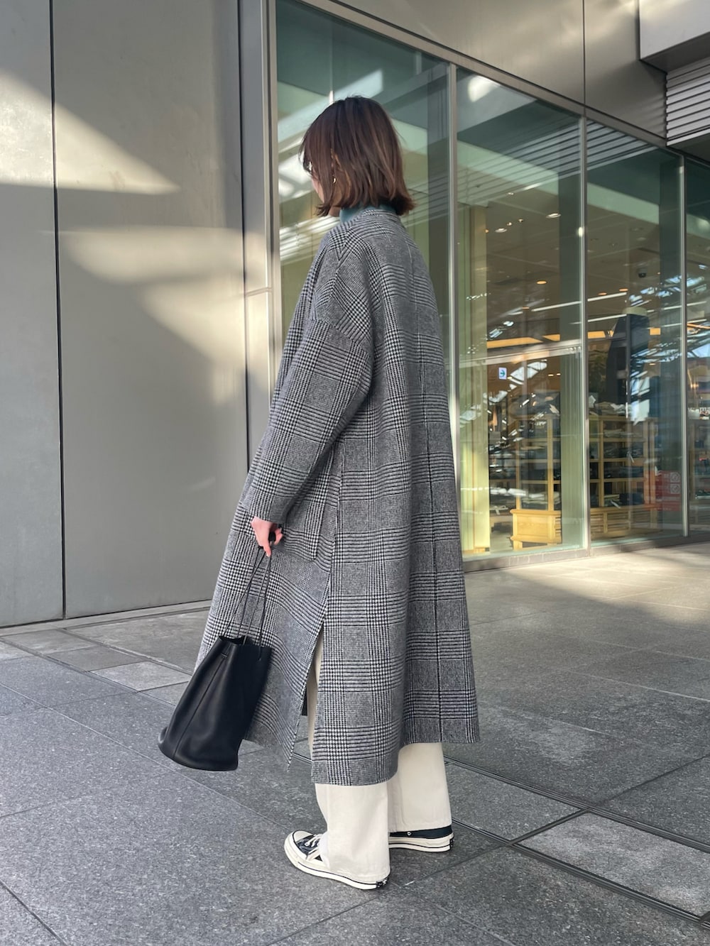 グレー系のその他アウター、ブルー系のニット/セーター、ホワイト系のデニムパンツを着用したレディースの冬コーディネートの4枚目の写真