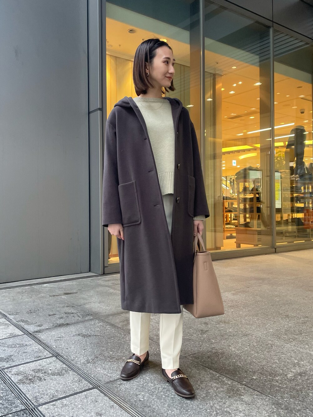 グレー系のその他アウター、グリーン系のニット/セーター、ベージュ系のトートバッグを着用したレディースの冬コーディネートの2枚目の写真