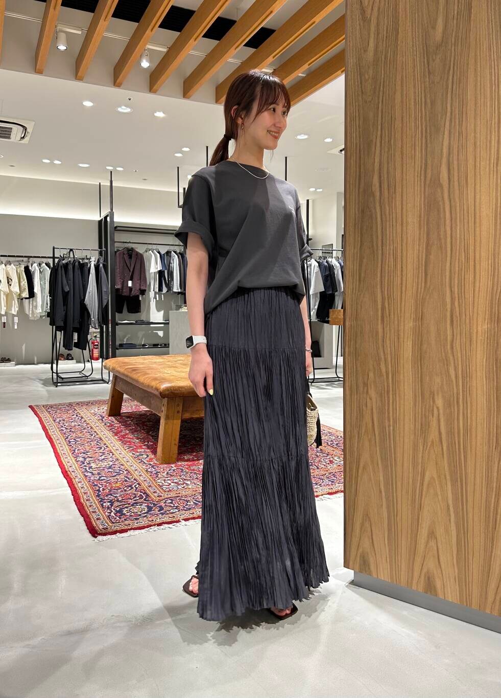 ベージュ系のかごバッグ、グレー系のTシャツ/カットソー、グレー系のスカートを着用したレディースの春コーディネートの2枚目の写真