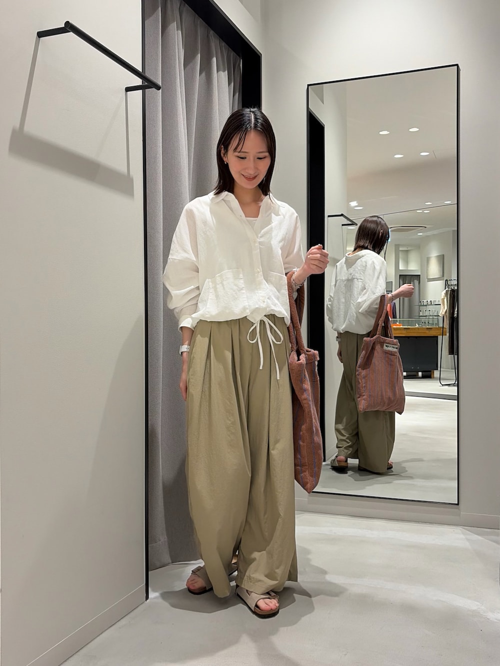 ベージュ系のその他パンツ、ベージュ系のサンダル、イエロー系のトートバッグを着用したレディースの春コーディネートの3枚目の写真