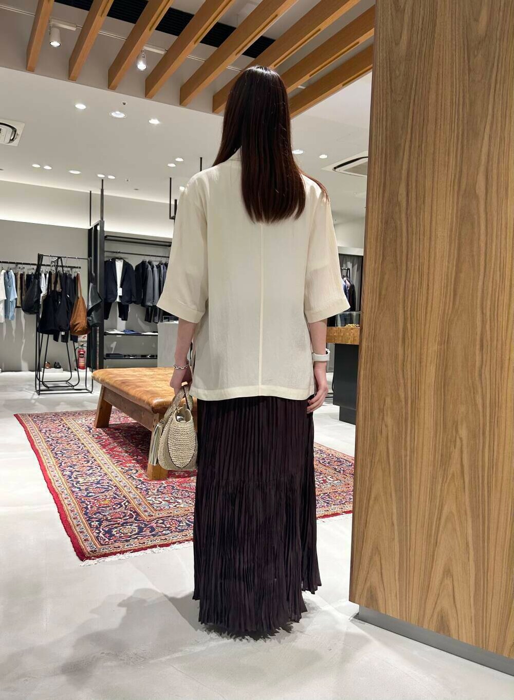 ベージュ系のかごバッグ、ブラウン系のスカート、ブラック系のサンダルを着用したレディースの夏コーディネートの3枚目の写真