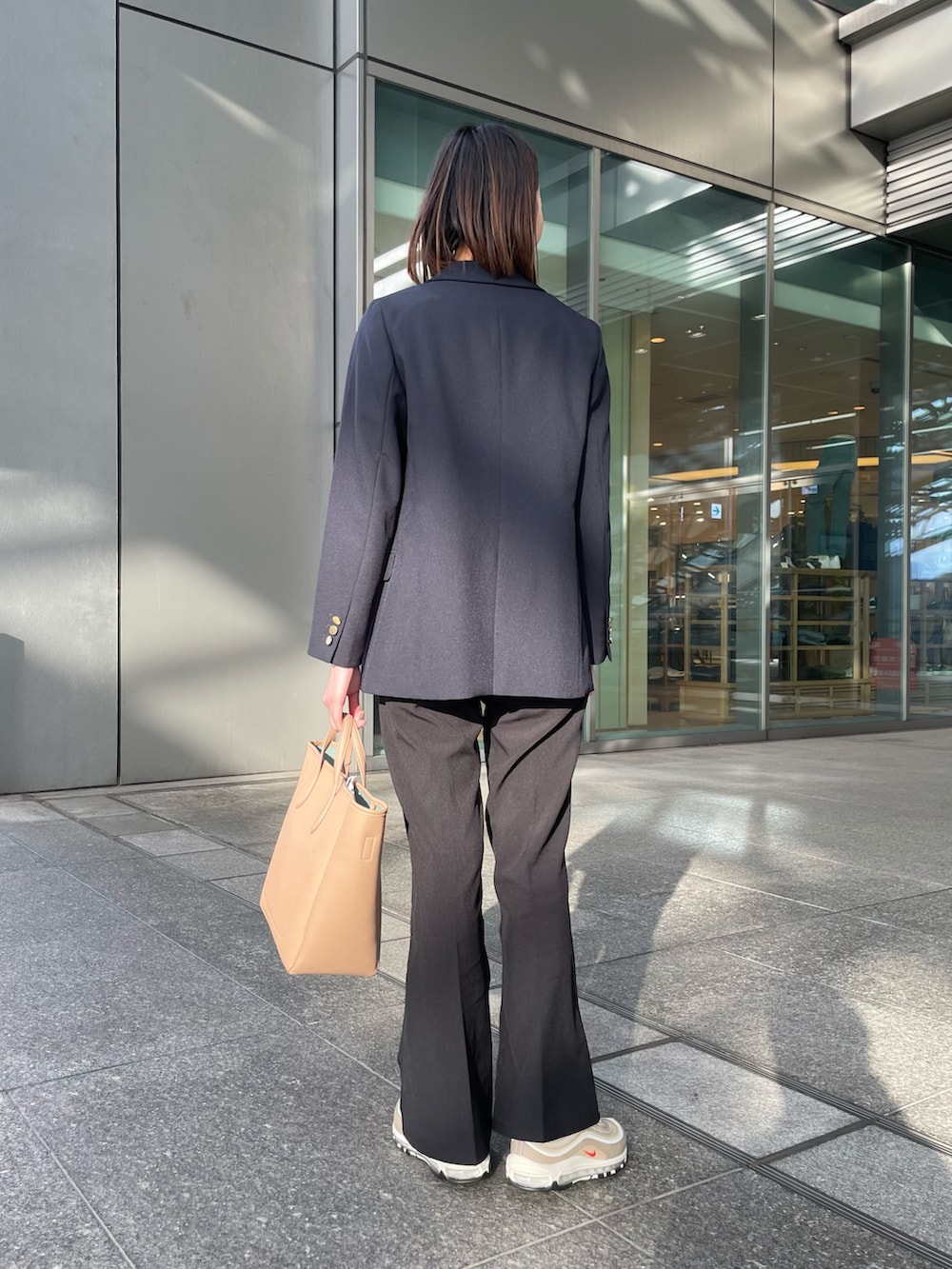 ブルー系のその他アウター、ベージュ系のニット/セーター、ベージュ系のトートバッグを着用したレディースの冬コーディネートの3枚目の写真