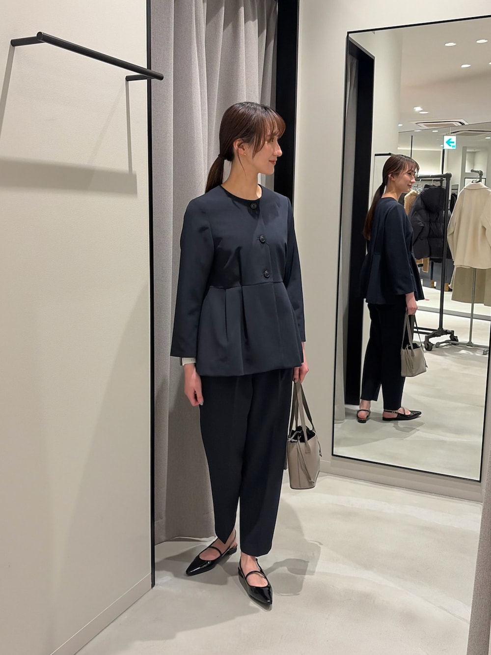 ブラック系のパンプス、ブルー系のノーカラージャケット、ブルー系のその他パンツを着用したレディースの冬コーディネートの3枚目の写真