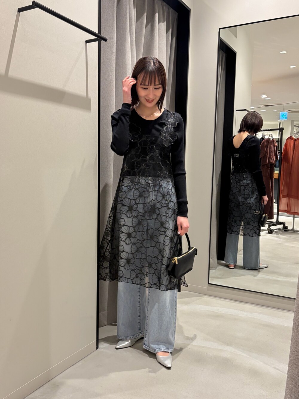 ブラック系のTシャツ/カットソー、ブルー系のデニムパンツ、シルバー系のパンプスを着用したレディースの冬コーディネートの4枚目の写真