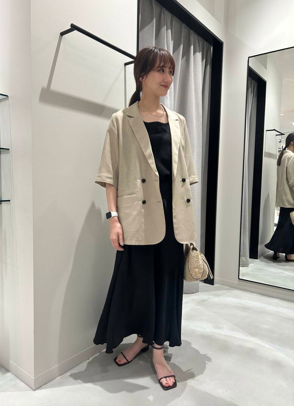 ベージュ系のかごバッグ、ブラック系のスカート、ベージュ系のその他アウターを着用したレディースの夏コーディネートの2枚目の写真