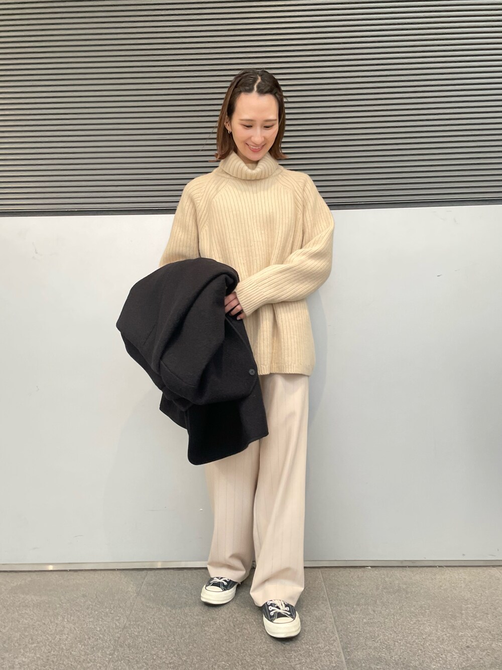 ブラック系のその他アウター、ベージュ系のショルダーバッグ、ベージュ系のニット/セーターを着用したレディースの冬コーディネートの2枚目の写真