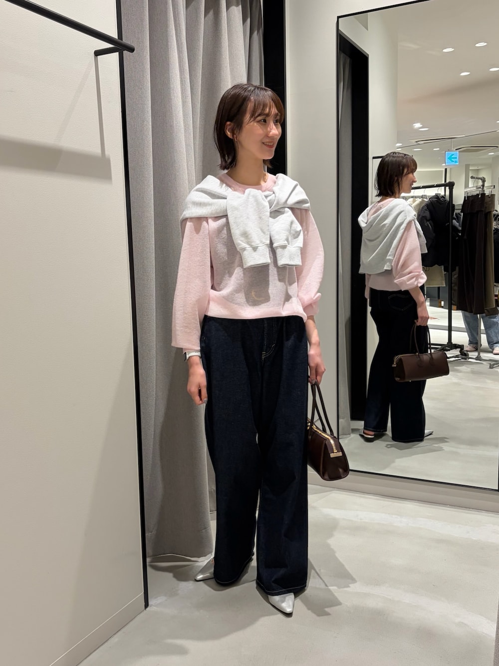 ピンク系のニット/セーター、グレー系のスウェット、ブルー系のデニムパンツを着用したレディースの冬コーディネートの2枚目の写真