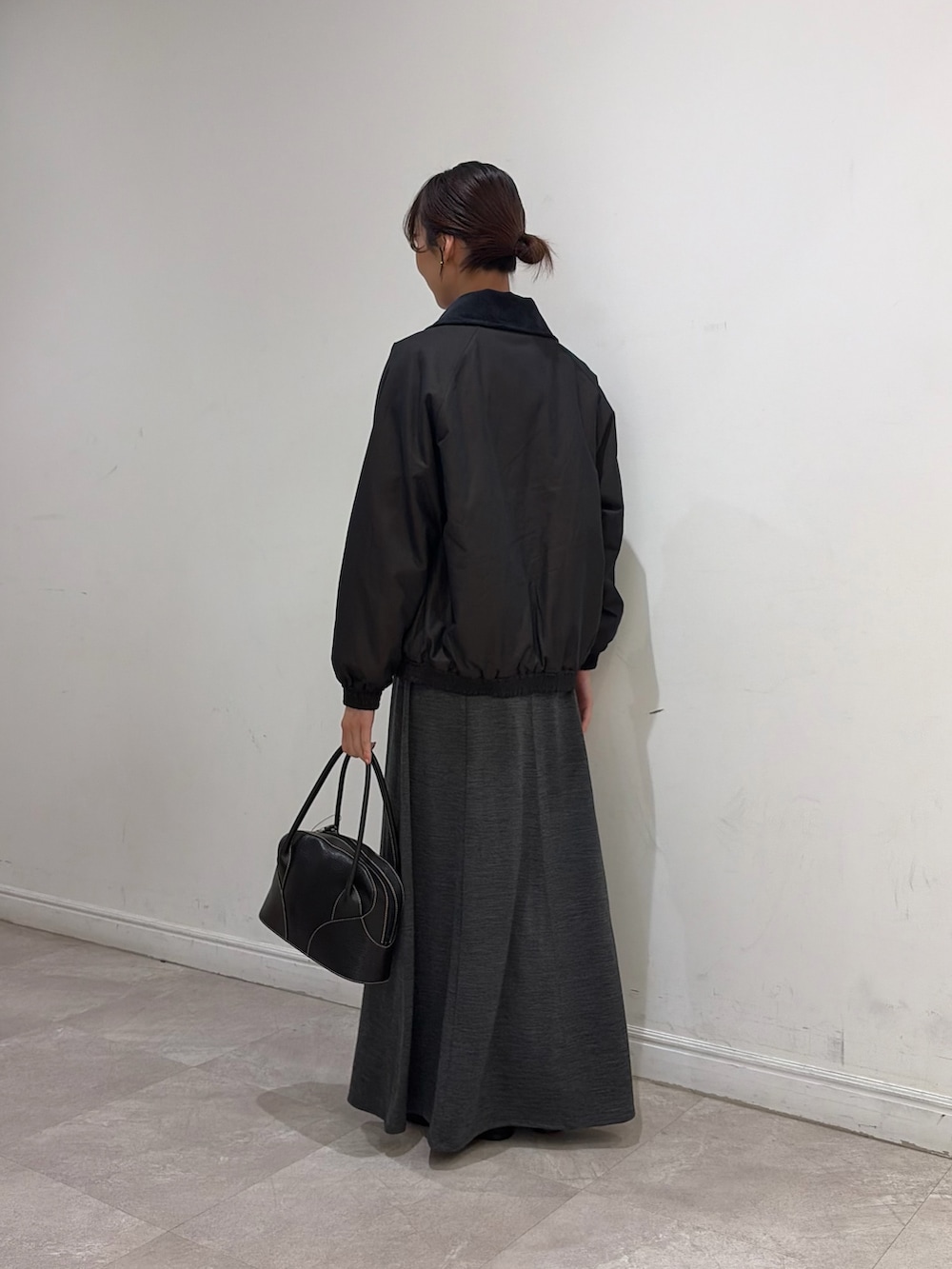 ブラウン系のダウンジャケット/コート、ブラック系のニット/セーター、グレー系のワンピースを着用したレディースの秋コーディネートの3枚目の写真
