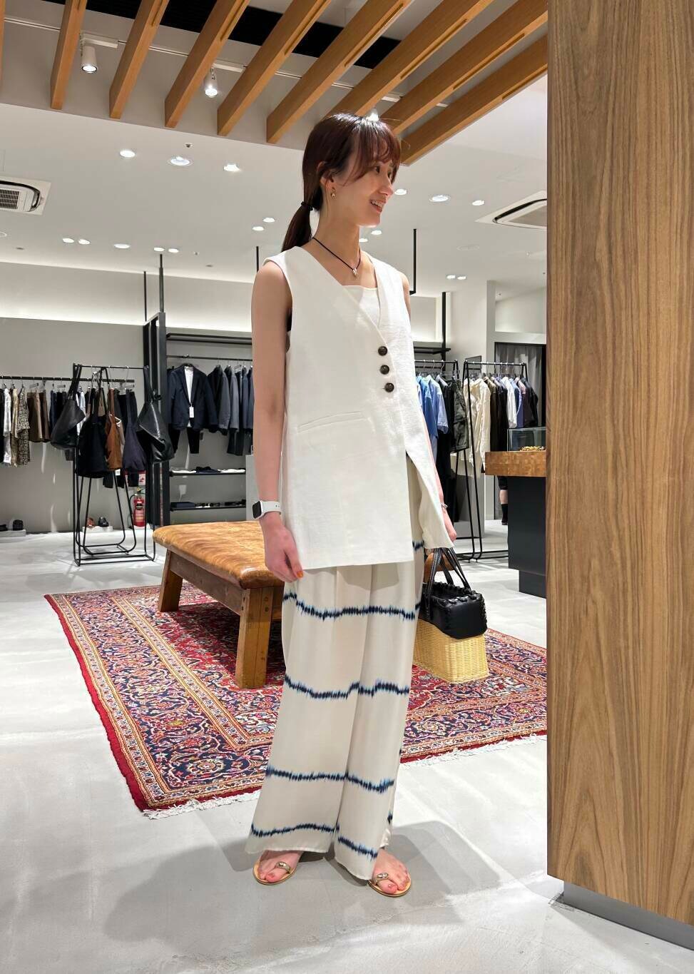 ホワイト系のタンクトップ、ゴールド系のサンダル、ホワイト系のその他パンツを着用したレディースの夏コーディネートの2枚目の写真