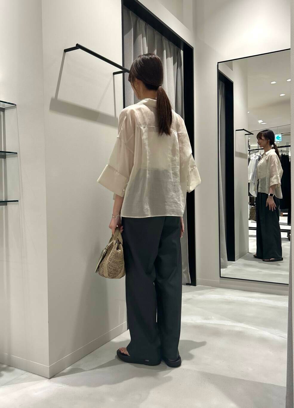 ゴールド系のかごバッグ、ブラック系のサンダル、グレー系のその他パンツを着用したレディースの夏コーディネートの4枚目の写真