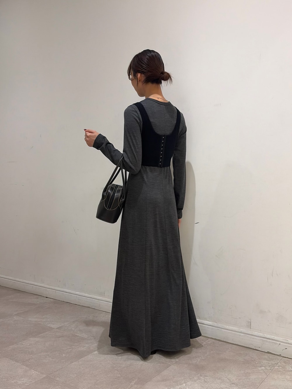 ブラウン系のダウンジャケット/コート、ブラック系のニット/セーター、グレー系のワンピースを着用したレディースの秋コーディネートの5枚目の写真