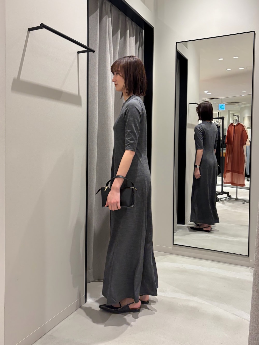 ブラック系のその他アウター、ブラック系のハンドバッグ、ブラック系のパンプスを着用したレディースの冬コーディネートの7枚目の写真