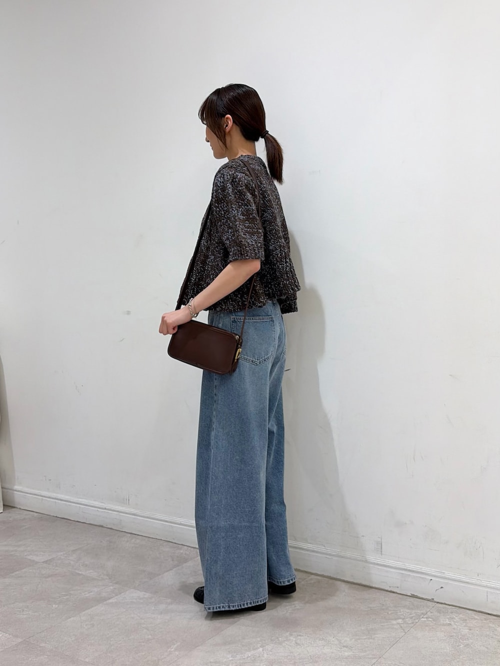 ブラウン系のニット/セーター、ブラック系のローファー、ブルー系のデニムパンツを着用したレディースの秋コーディネートの3枚目の写真