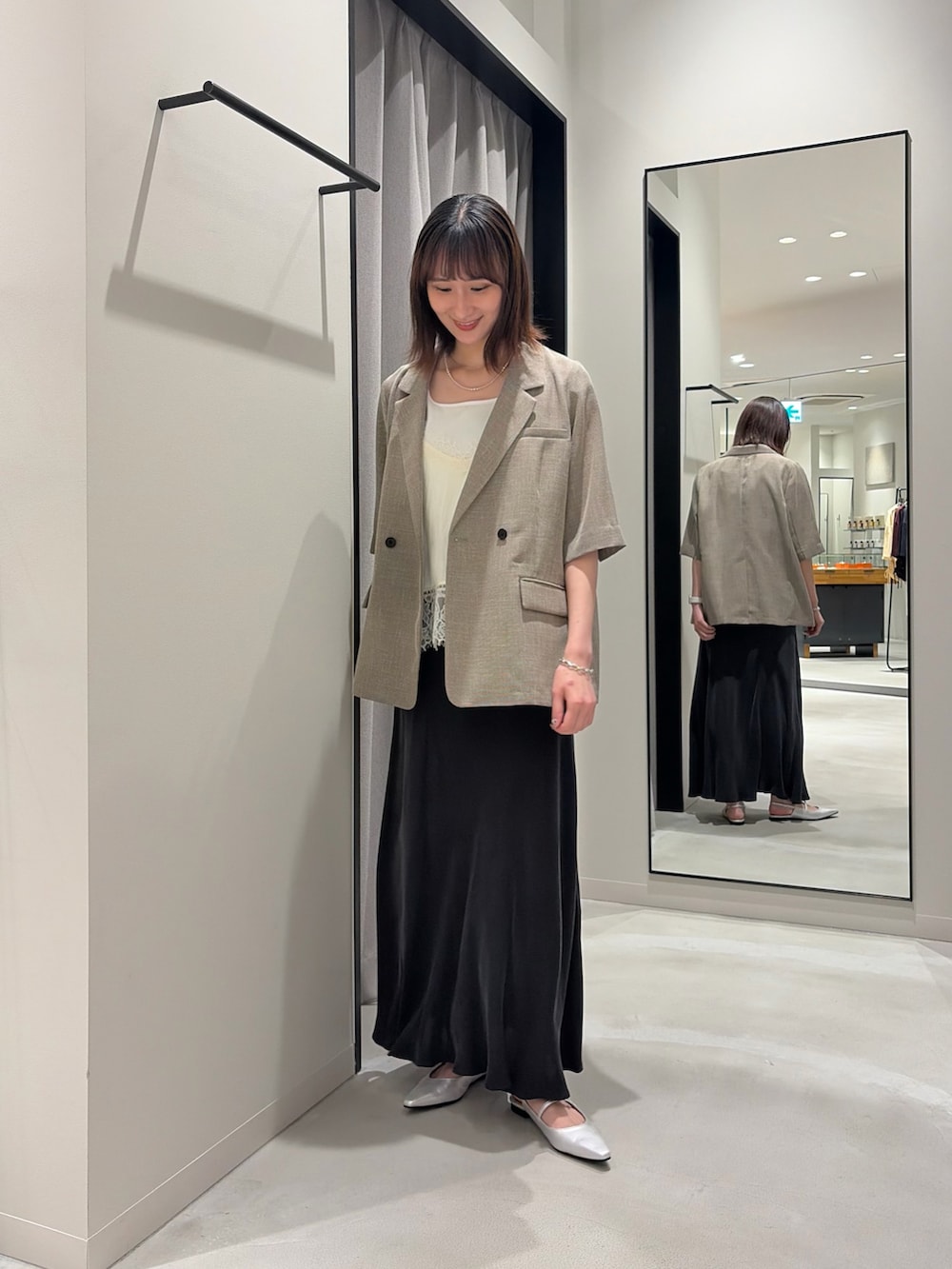 ベージュ系のその他アウター、グレー系のスカート、シルバー系のパンプスを着用したレディースの春コーディネートの2枚目の写真