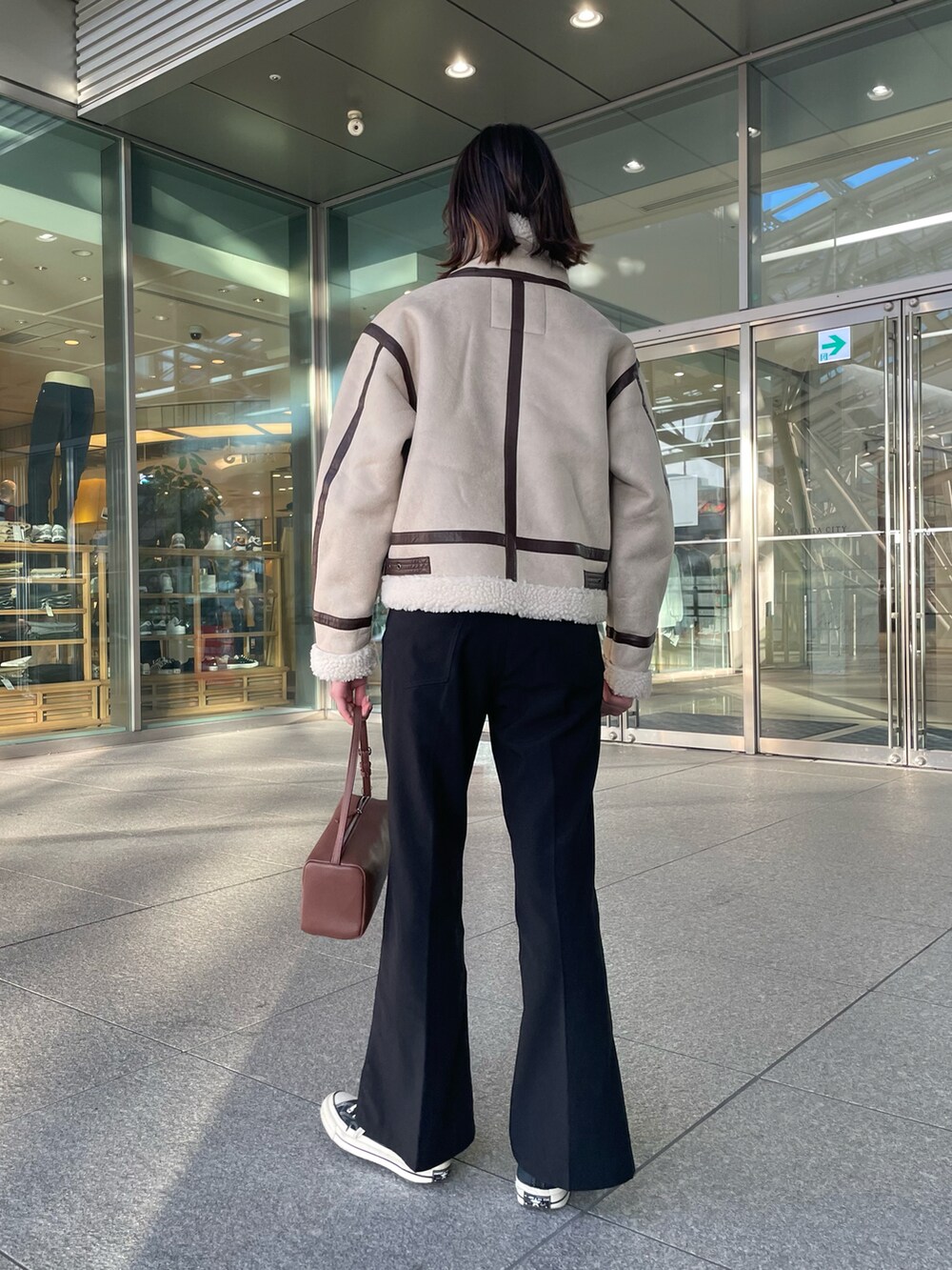 ベージュ系のブルゾン、ブラック系のその他パンツ、ブラウン系のボストンバッグを着用したレディースの冬コーディネートの5枚目の写真