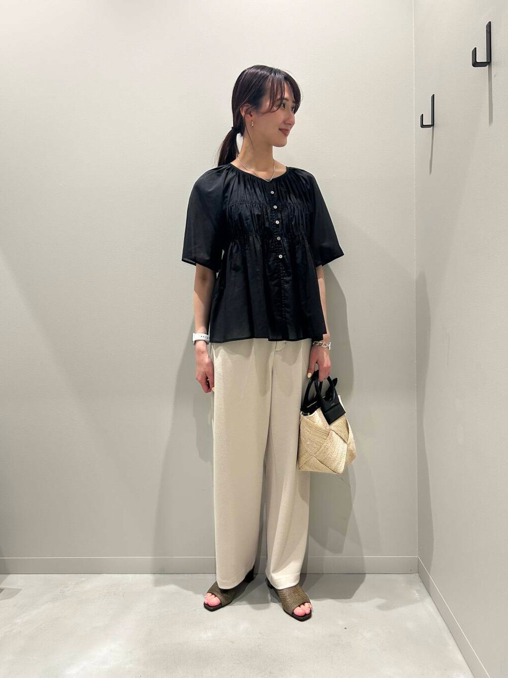 ベージュ系のショルダーバッグ、ブラウン系のサンダル、ベージュ系のその他パンツを着用したレディースの春コーディネートの2枚目の写真