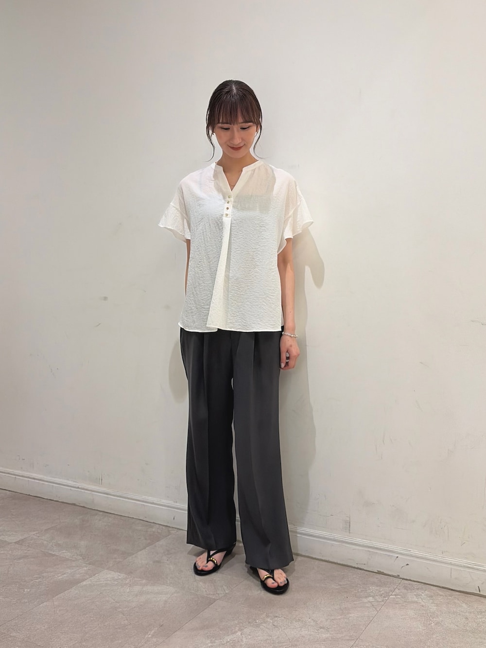 ホワイト系のシャツ/ブラウス、グレー系のその他パンツ、ブラック系のサンダルを着用したレディースの夏コーディネートの3枚目の写真