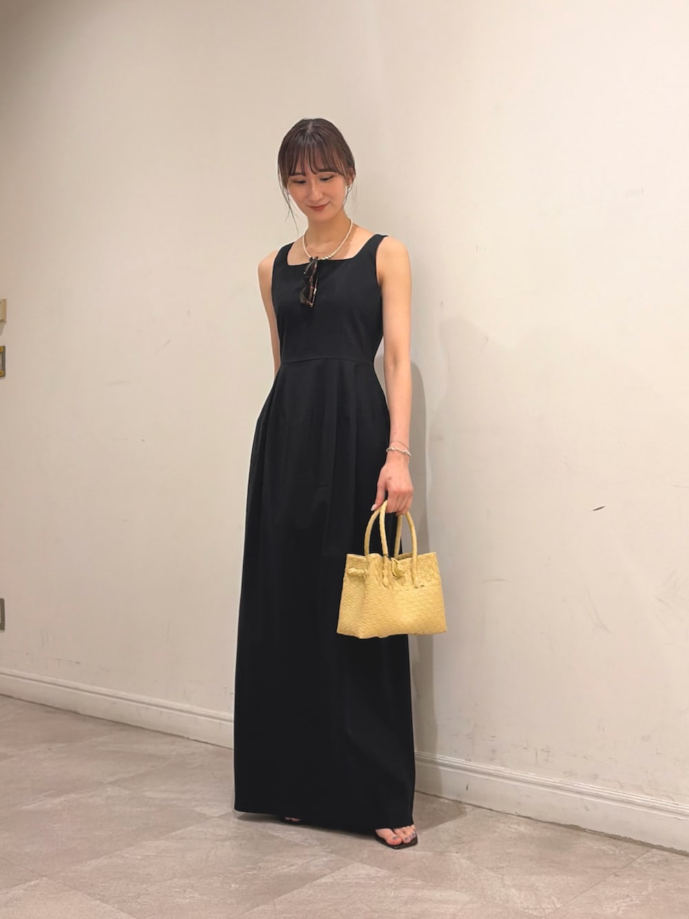 ホワイト系のシャツ/ブラウス、ブラック系のワンピース、ベージュ系のトートバッグを着用したレディースの夏コーディネートの2枚目の写真