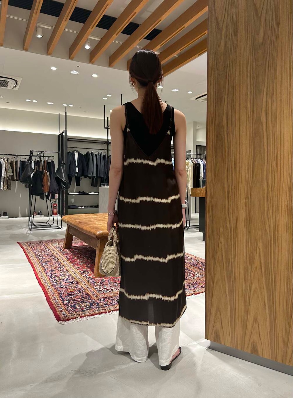 ベージュ系のかごバッグ、ブラック系のタンクトップ、ホワイト系のその他パンツを着用したレディースの夏コーディネートの4枚目の写真