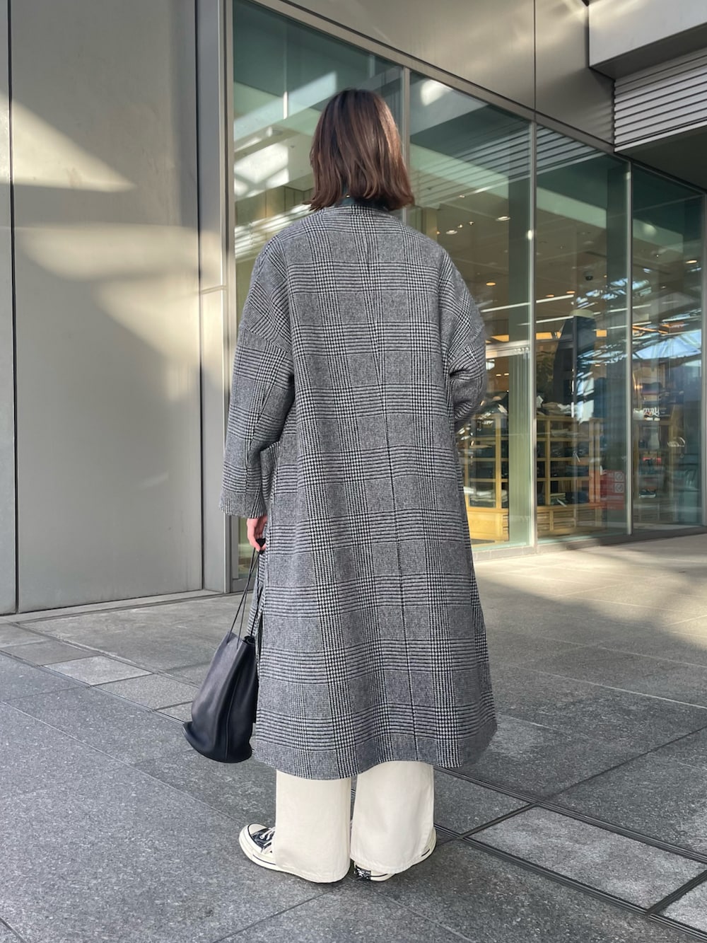 グレー系のその他アウター、ブルー系のニット/セーター、ホワイト系のデニムパンツを着用したレディースの冬コーディネートの3枚目の写真