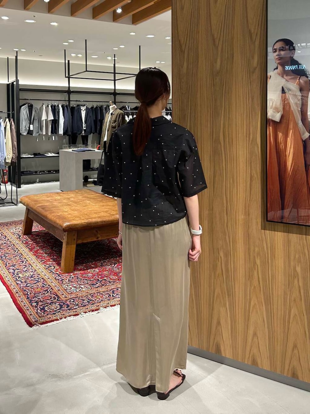 ブラック系のシャツ/ブラウス、ブラウン系のサンダル、ベージュ系のスカートを着用したレディースの春コーディネートの2枚目の写真